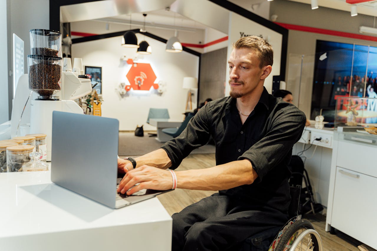 Hombre en silla de ruedas usando un ordenador en su casa